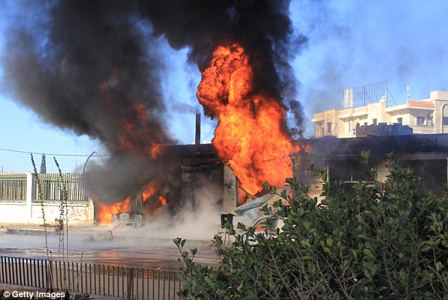 MI6 and British police are investigating alleged attacks on civilians by Russian war planes in Syria. Flames are pictured rising after the Russian army carried out airstrikes on two hospitals in Aleppo, Syria, last December